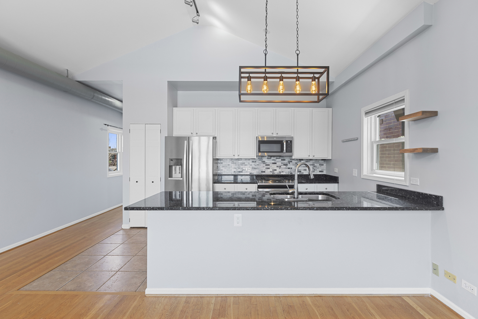1267 North Honore Street, Unit 3 Chicago, IL 60622 - Photo 5 of 17 a large kitchen with stainless steel appliances granite countertop a stove a sink and a granite counter tops