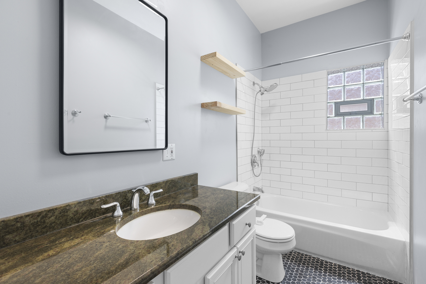 1267 North Honore Street, Unit 3 Chicago, IL 60622 - Photo 9 of 17 a bathroom with a granite countertop sink toilet a mirror and bathtub
