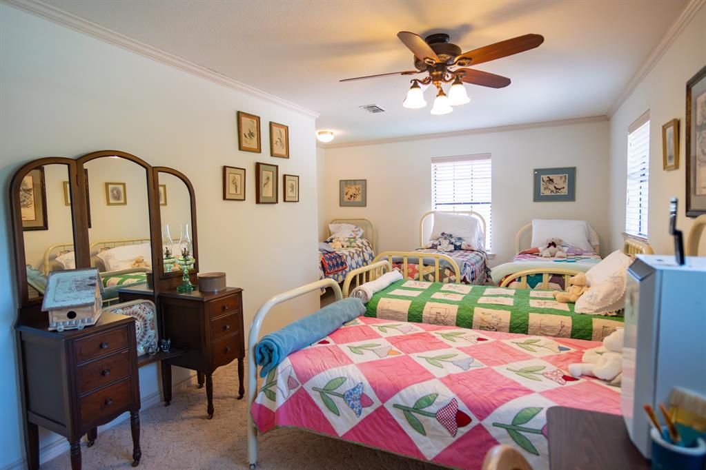 408 Rainey Street Bonham, TX 75418 - Photo 23 of 40 a bedroom with a bed a desk and chair with window