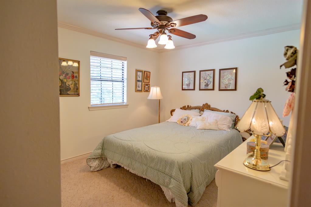 408 Rainey Street Bonham, TX 75418 - Photo 25 of 40 a bedroom with a bed and a chandelier
