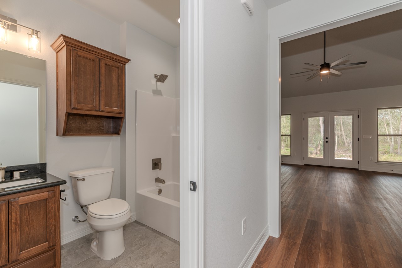 7820 Tolivar Road Beaumont, TX 77713 - Photo 12 of 47 a bathroom with a toilet a sink and a window