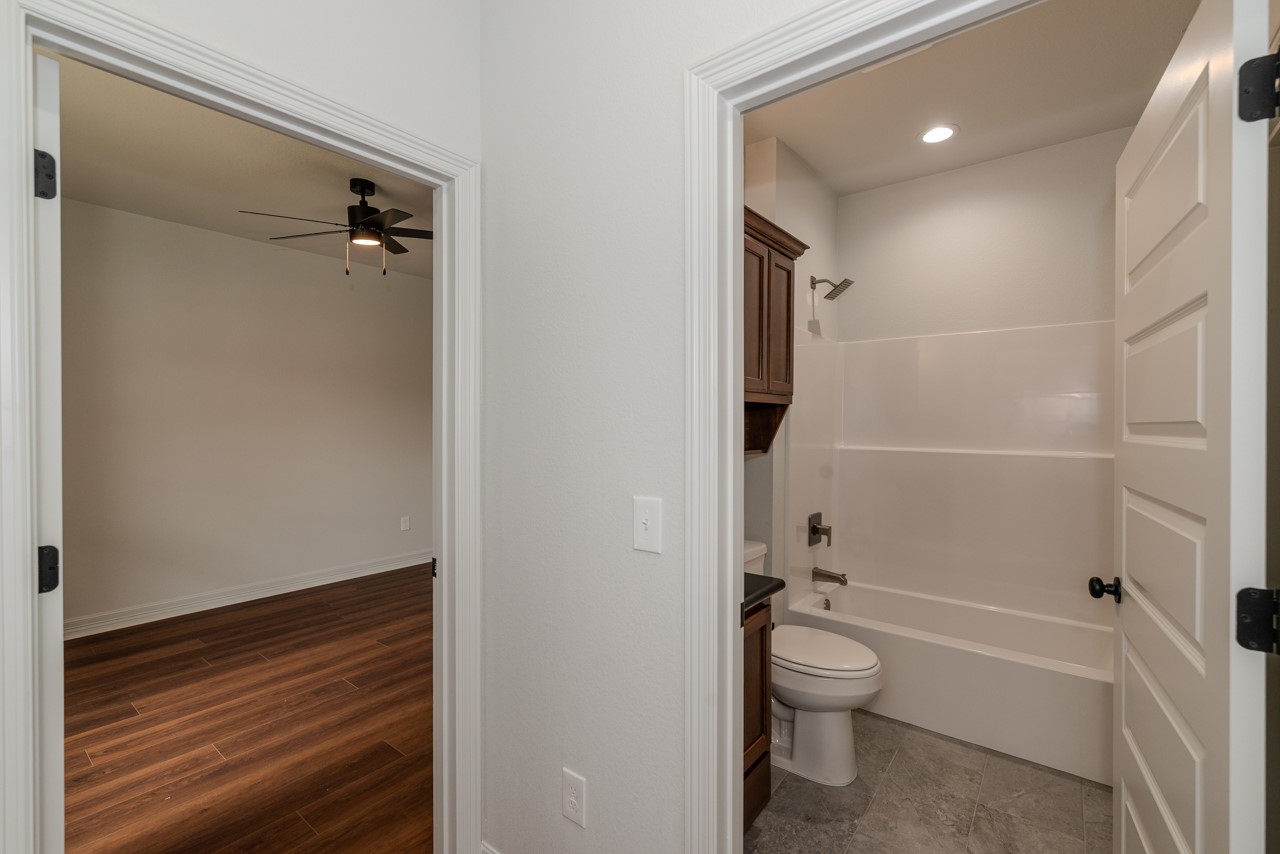 7820 Tolivar Road Beaumont, TX 77713 - Photo 14 of 47 a bathroom with a granite countertop toilet a sink and bathtub