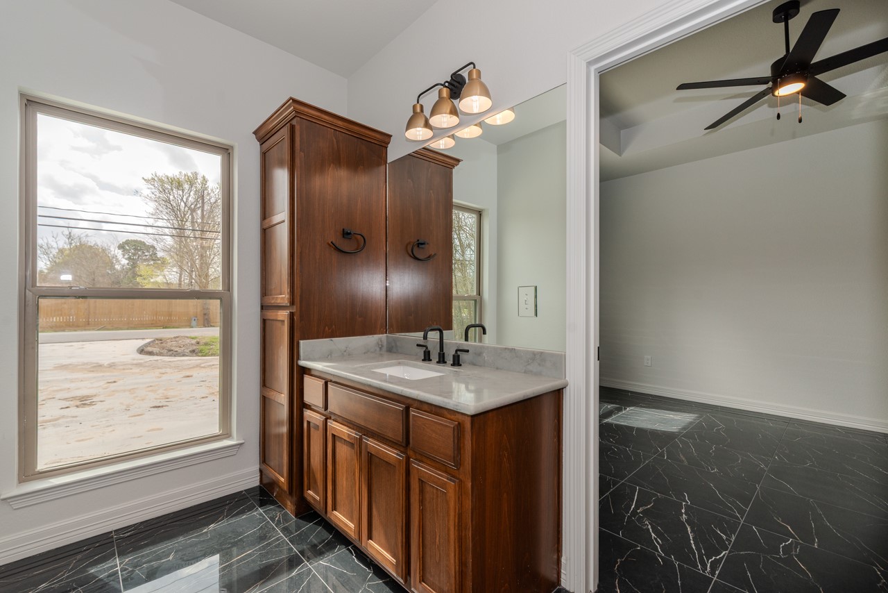 7820 Tolivar Road Beaumont, TX 77713 - Photo 34 of 47 a bathroom with a granite countertop sink a large mirror and a shower