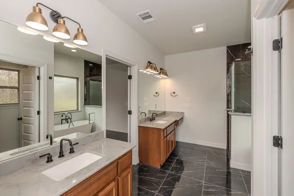 a en suite bathroom with a double vanity sink a mirror and shower