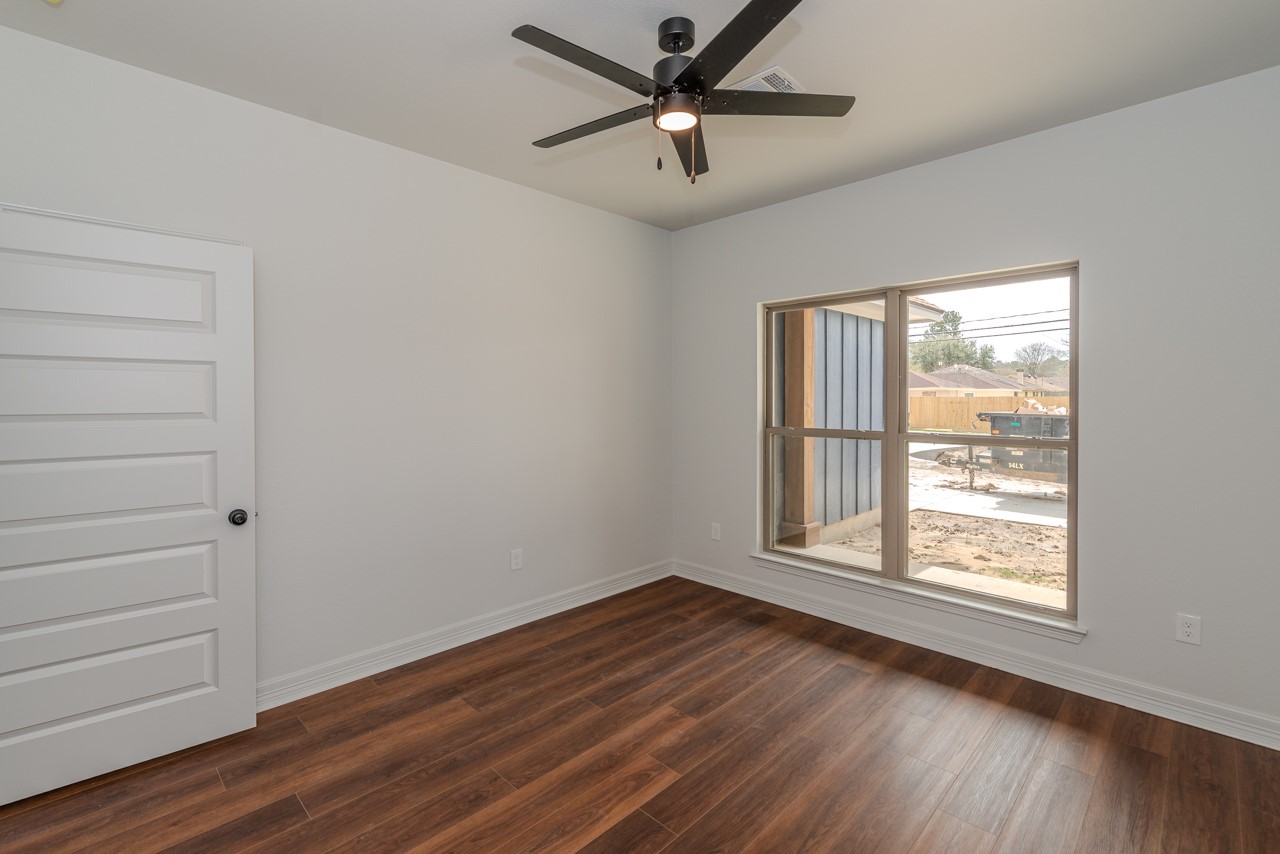 7820 Tolivar Road Beaumont, TX 77713 - Photo 41 of 47 a view of an empty room with a window and wooden floor