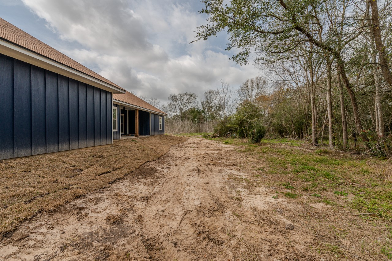7820 Tolivar Road Beaumont, TX 77713 - Photo 46 of 47 a backyard of a house with large trees and wooden fence
