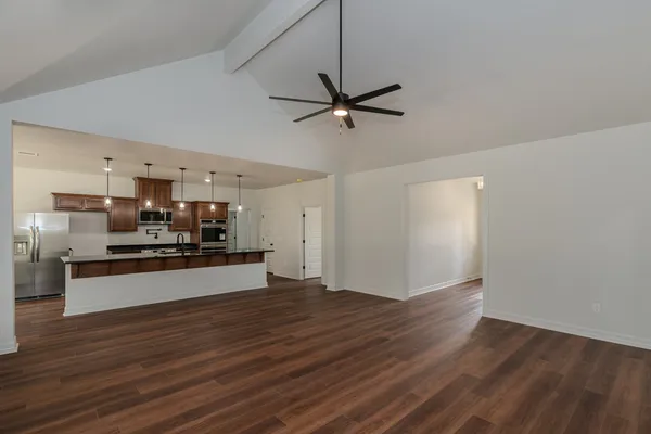 a kitchen with stainless steel appliances kitchen island wooden floors and view living room
