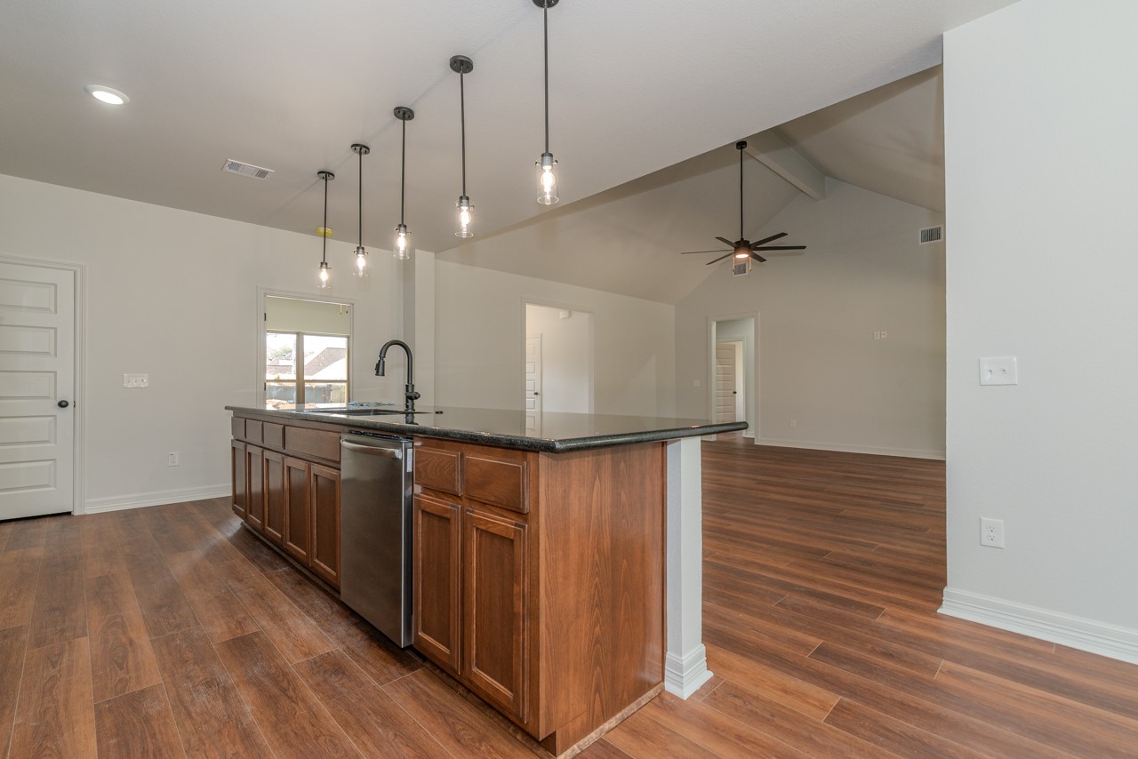 7820 Tolivar Road Beaumont, TX 77713 - Photo 8 of 47 a kitchen with stainless steel appliances granite countertop a sink a refrigerator and wooden floor
