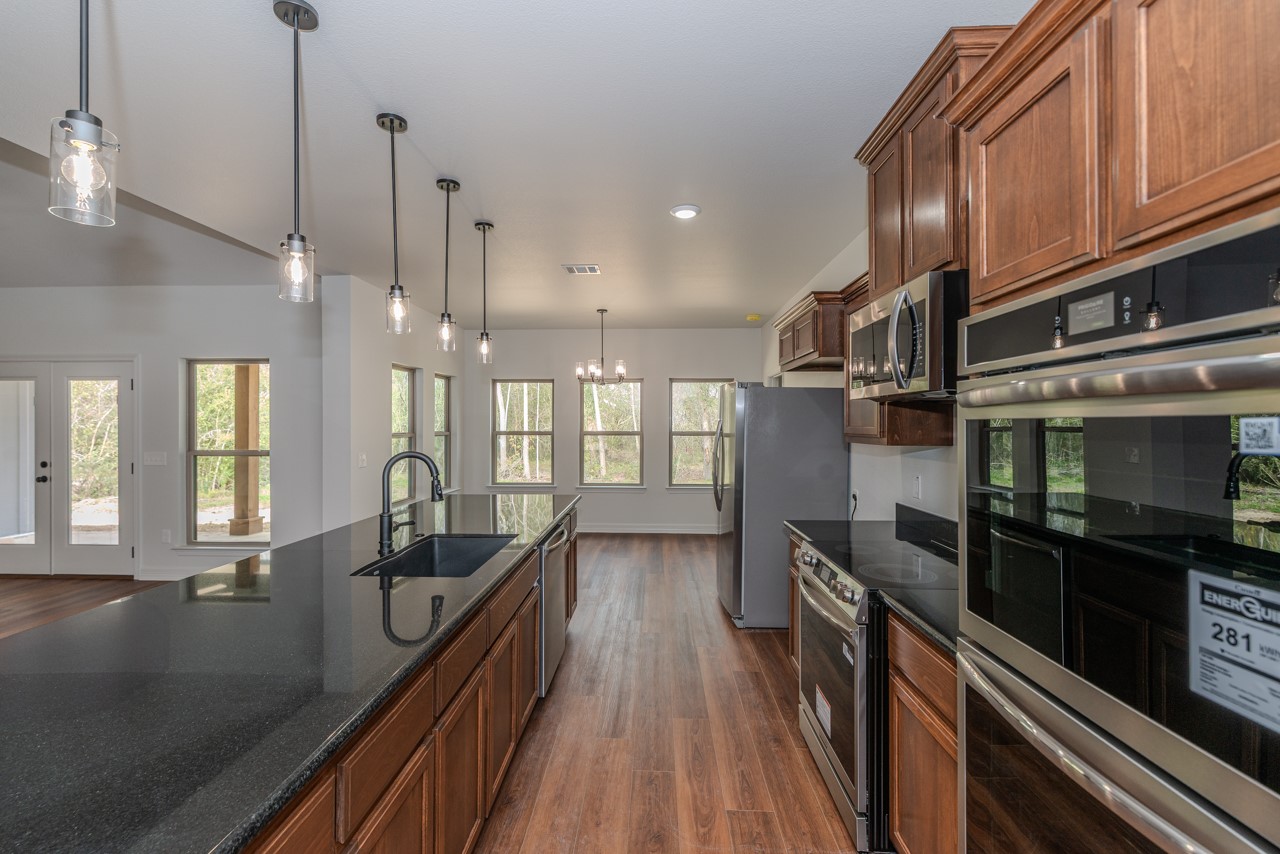 7820 Tolivar Road Beaumont, TX 77713 - Photo 10 of 47 a open kitchen with stainless steel appliances granite countertop a refrigerator a stove and a wooden floors