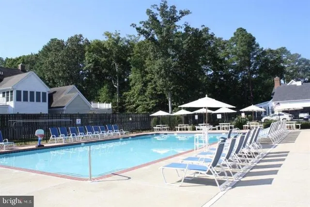 a view of a swimming pool with lawn chairs under an umbrella
