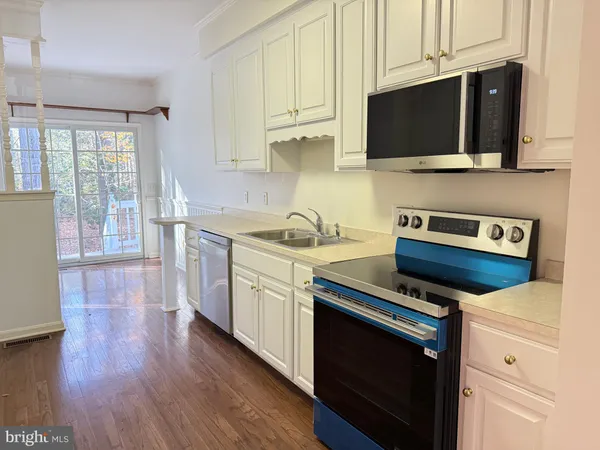 a kitchen with stainless steel appliances a stove a microwave a sink and cabinets