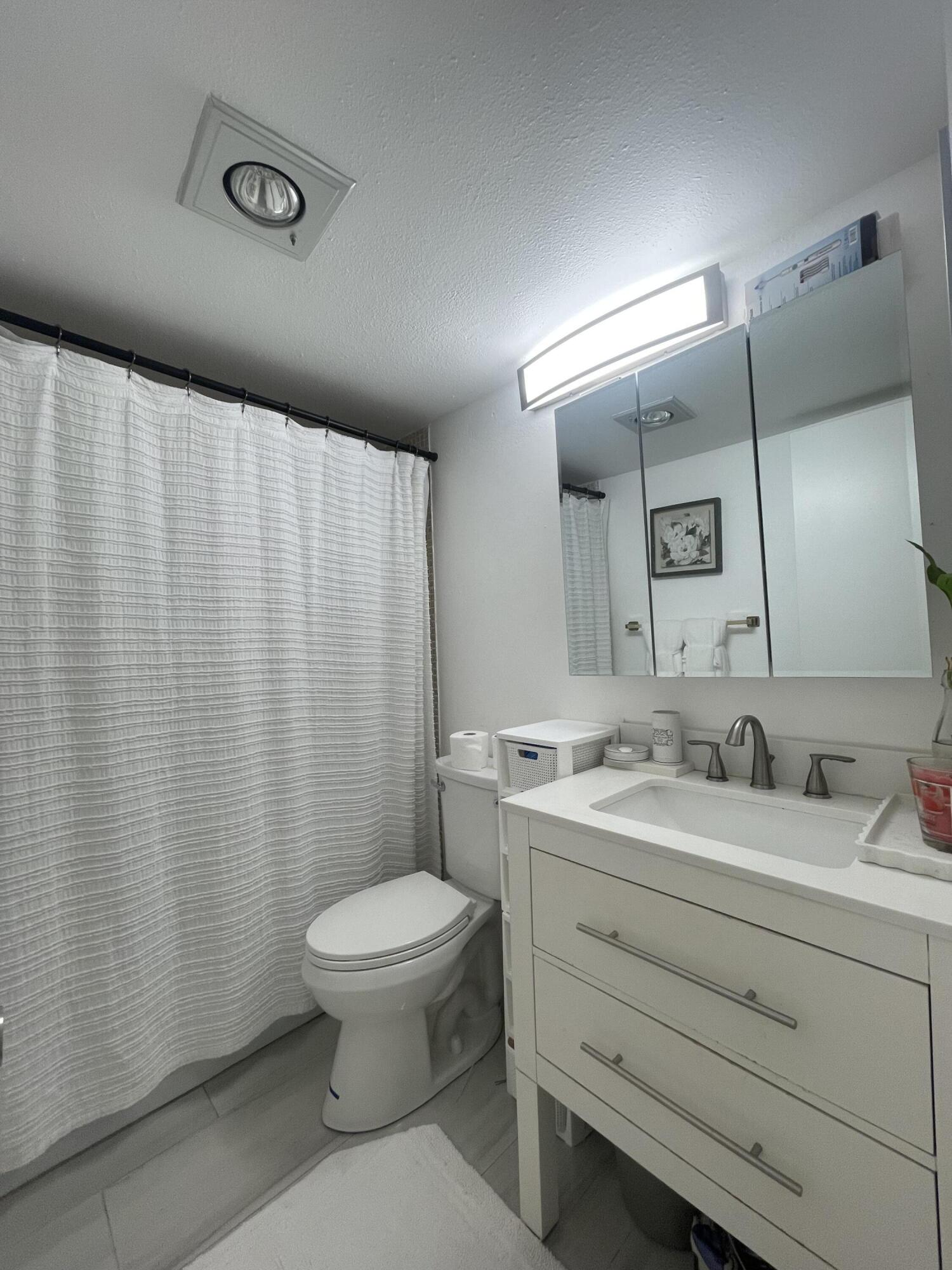 49 Mansfield B Boca Raton, FL 33434 - Photo 13 of 31 a bathroom with a granite countertop sink toilet and mirror