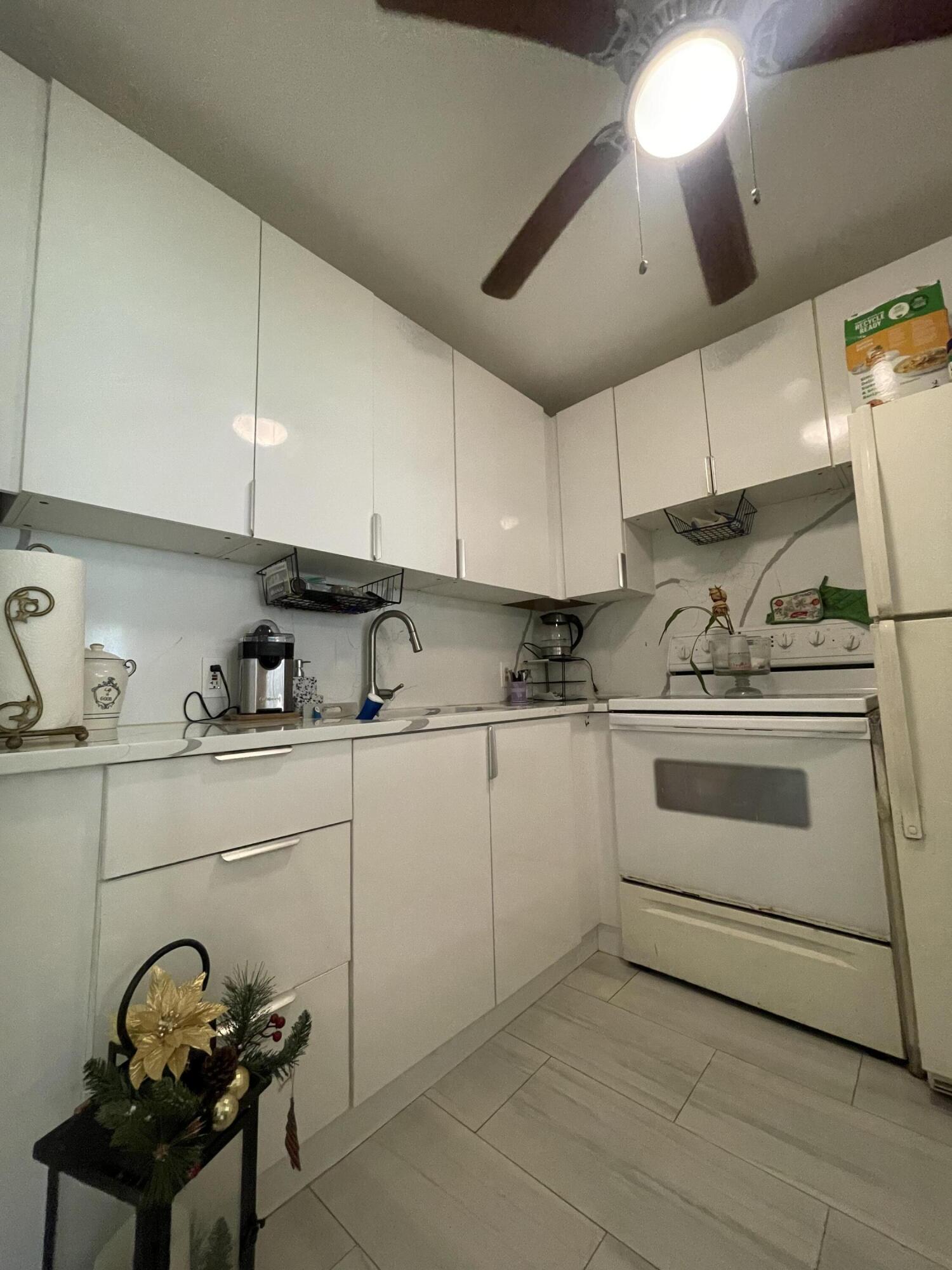 49 Mansfield B Boca Raton, FL 33434 - Photo 7 of 31 a kitchen with a stove cabinets and a sink