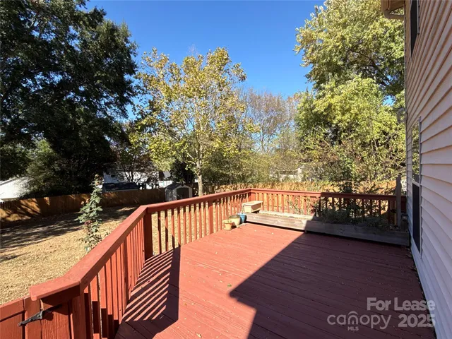 a balcony with wooden floor and yard in the back