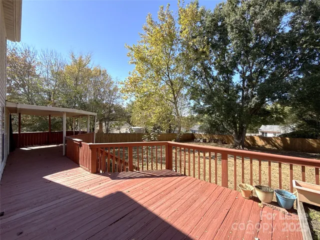 a balcony with wooden floor and yard