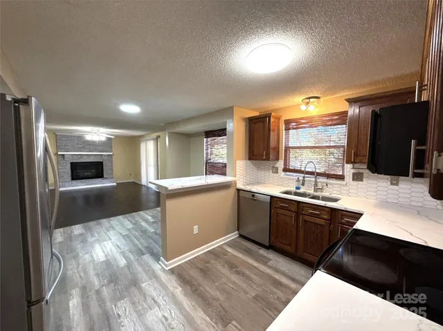 a kitchen with stainless steel appliances kitchen island granite countertop a sink counter space cabinets and a stove