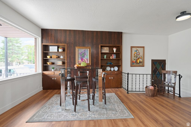 673 East 700 South Springville, UT 84663 - Photo 16 of 43 Wood-finish flooring throughout, featuring a prominent wood paneled accent wall and built-in shelving units