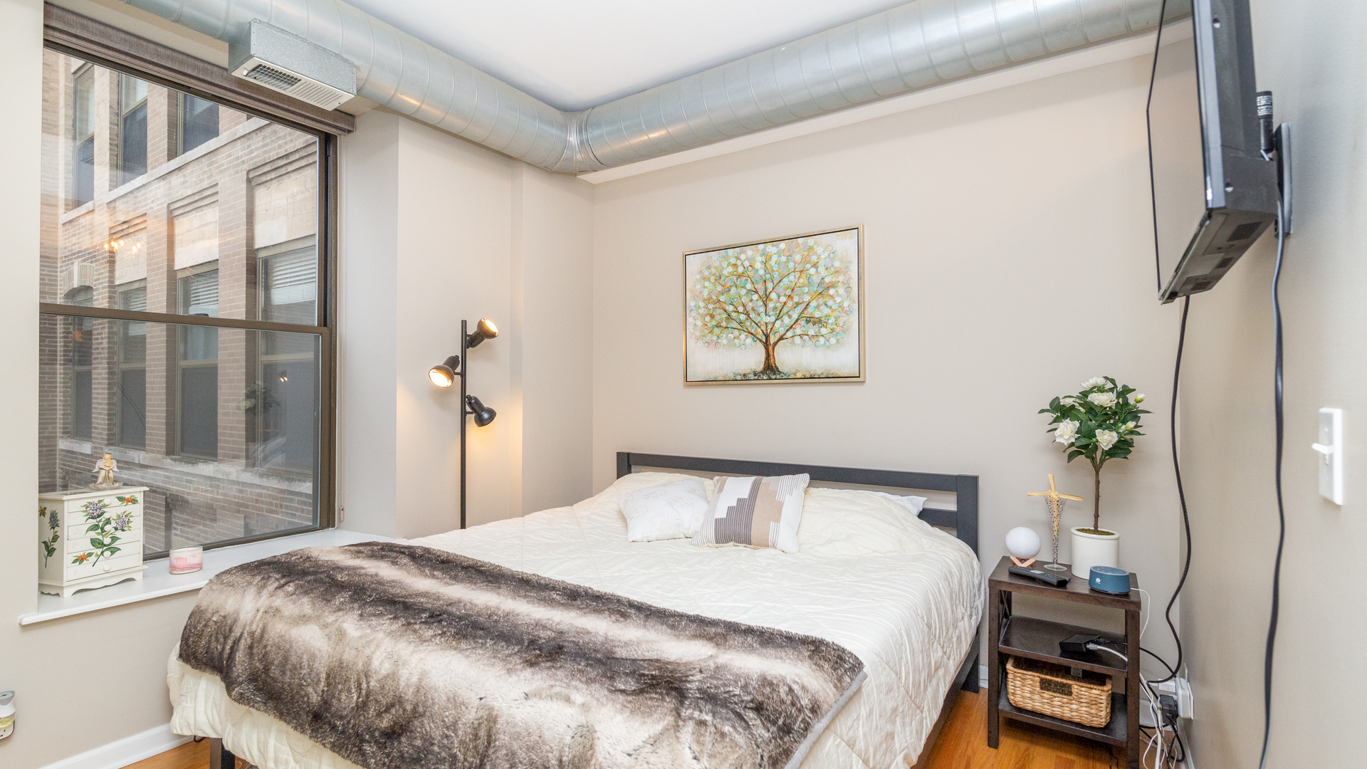 811 South Lytle Street, Unit 319 Chicago, IL 60607 - Photo 10 of 29 a bedroom with a bed and a potted plant on the dresser