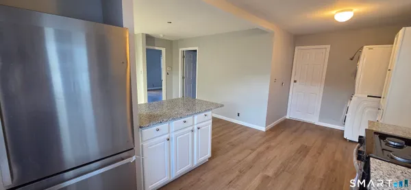 a view of a kitchen with a refrigerator and a stove top oven