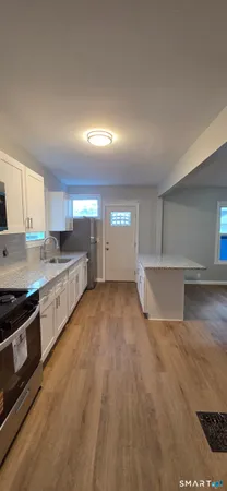 a kitchen with stainless steel appliances granite countertop a sink stove and cabinets