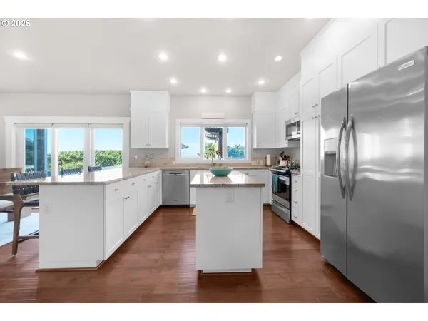 a large kitchen with kitchen island a large counter top space a sink stainless steel appliances and cabinets