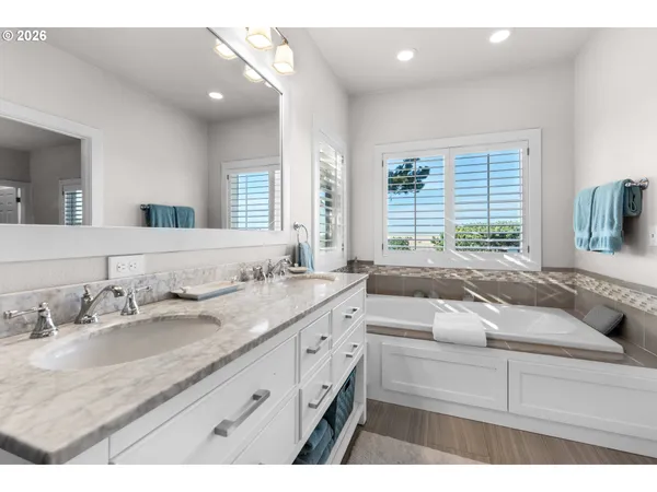 a bathroom with a granite countertop sink a large mirror and a window