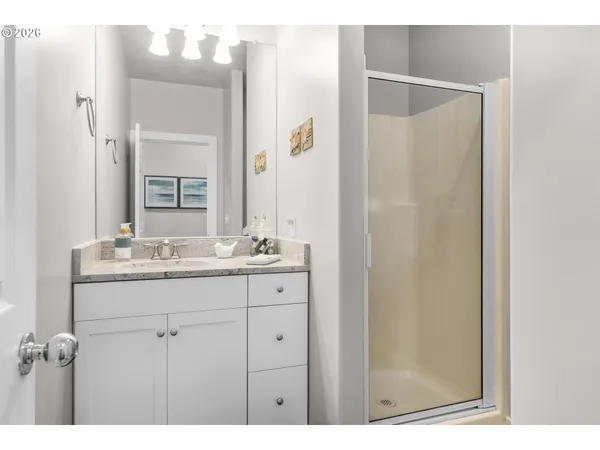 a bathroom with a shower sink and mirror