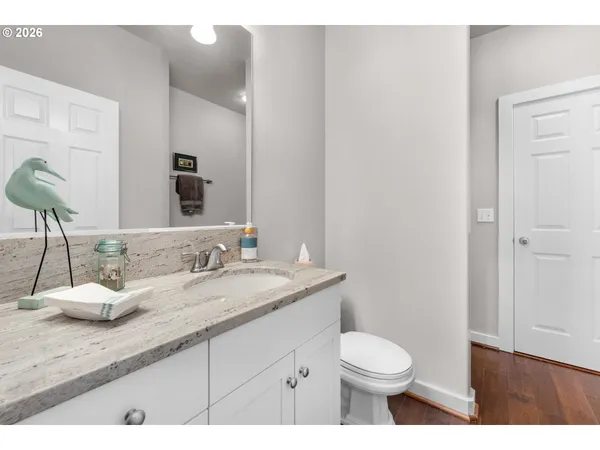a bathroom with a granite countertop toilet sink and mirror