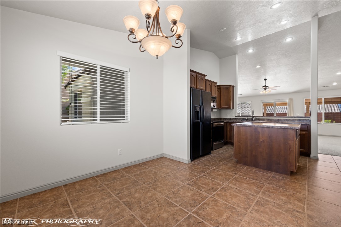 874 Glendale Road Mesquite, NV 89027 - Photo 33 of 71 A well-lit eat-in kitchen with warm cabinetry and durable tile flooring.