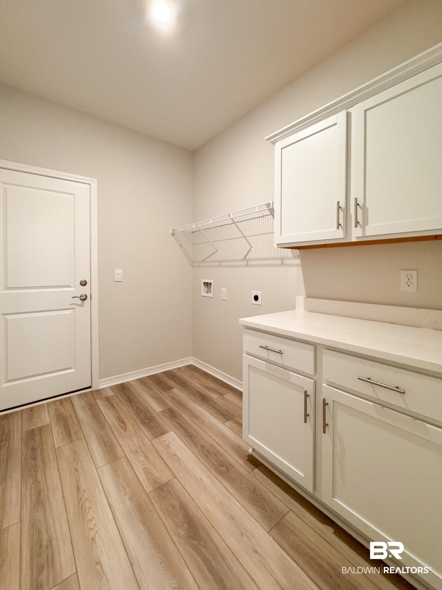 23939 Dominus Drive Daphne, AL 36526 - Photo 8 of 9 Laundry room featuring washer hookup, light wood-style flooring, hookup for an electric dryer, and cabinet space