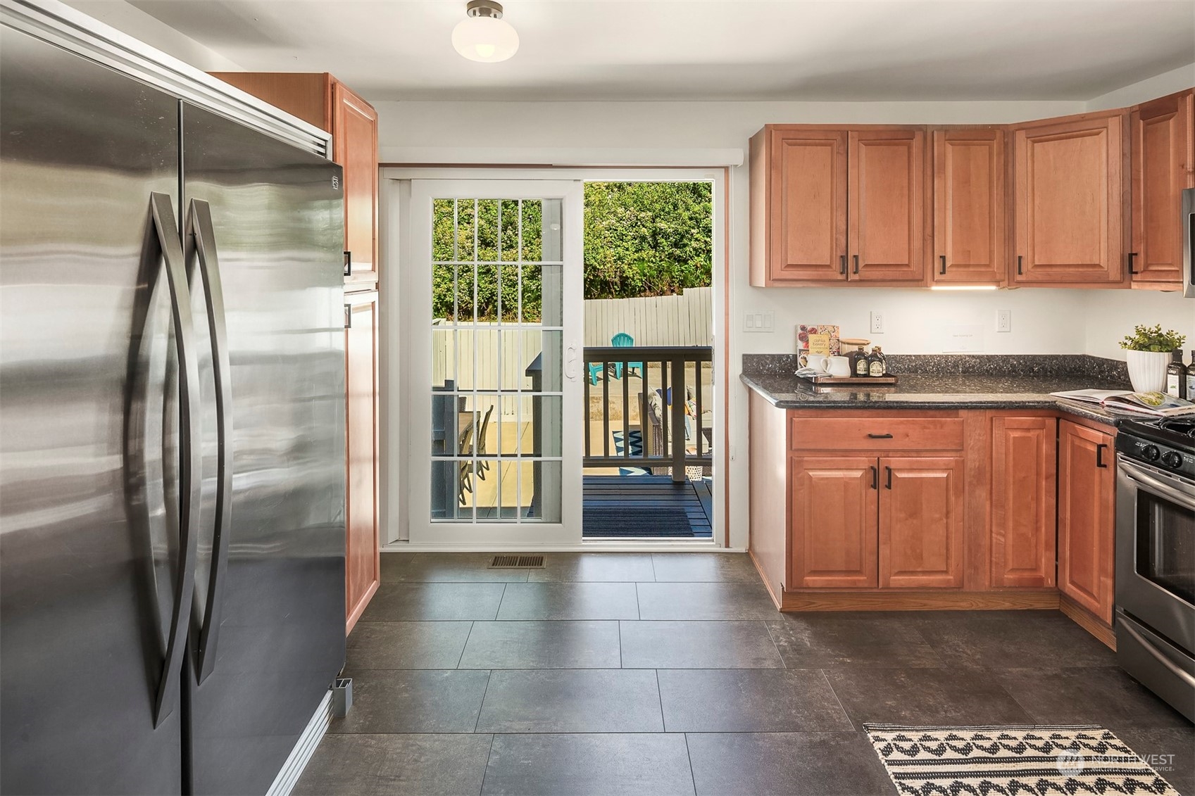 3226 60th Avenue Southwest Seattle, WA 98116 - Photo 9 of 34 a kitchen with stainless steel appliances granite countertop a refrigerator a sink a stove and cabinets