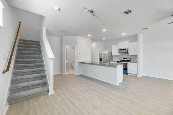a large kitchen with stainless steel appliances granite countertop a stove a sink and a refrigerator