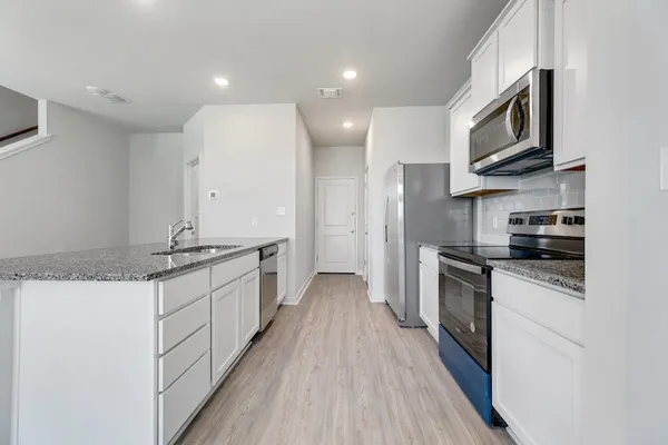 a kitchen with a sink stove and cabinets