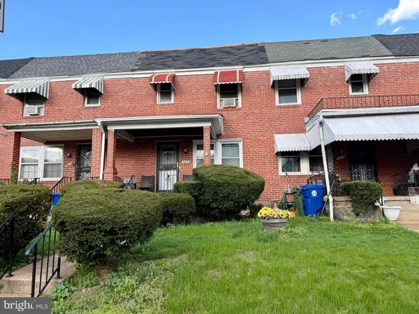 a view of brick house with a yard and plants