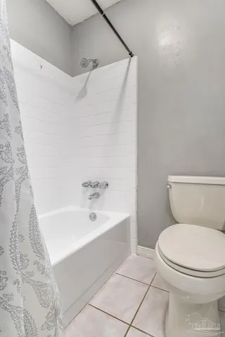 a white toilet sitting next to a bath tub