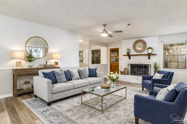 a living room with furniture a fireplace and a large window
