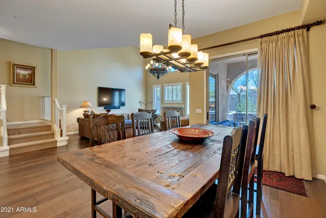 a living room with furniture a chandelier and a flat screen tv