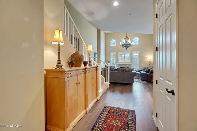 a view of a hallway with couches and a potted plant on a table