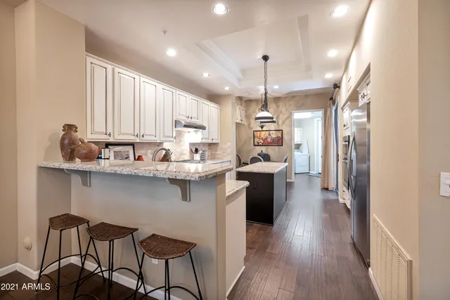 a kitchen with kitchen island granite countertop a sink cabinets and wooden floor