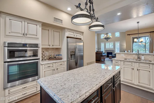 a kitchen with stainless steel appliances granite countertop a stove refrigerator and microwave