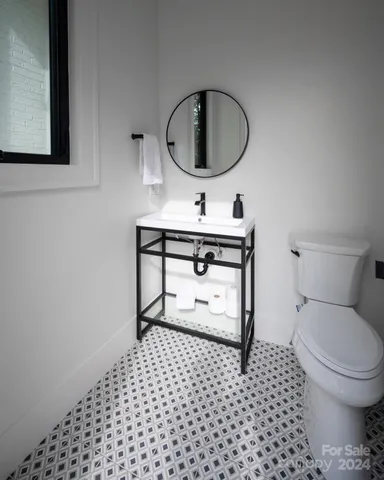 a bathroom with a toilet a sink and a mirror