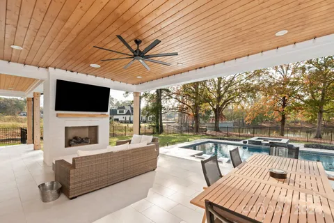 a living room with patio furniture and a flat screen tv