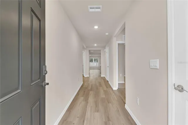 a view of a hallway with wooden floor