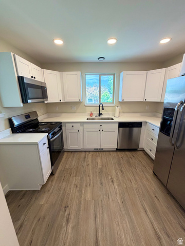 450 13800 South, Unit 2 Draper, UT 84020 - Photo 12 of 21 U-shaped kitchen featuring white shaker-style cabinetry, stainless steel appliances, light-toned countertops, wood-finish flooring, and recessed lighting