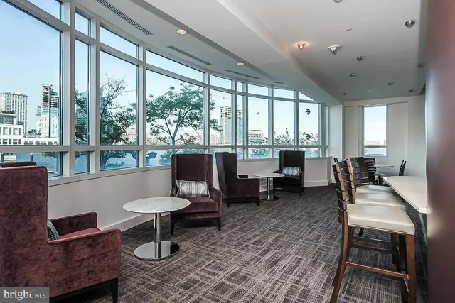 a living room with furniture and large windows