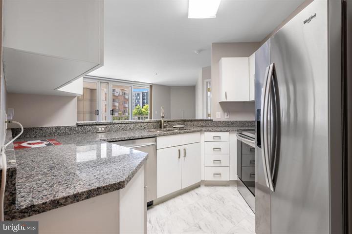 100 Harborview Drive, Unit 212 Baltimore, MD 21230 - Photo 8 of 29 a kitchen with stainless steel appliances granite countertop a sink refrigerator and cabinets