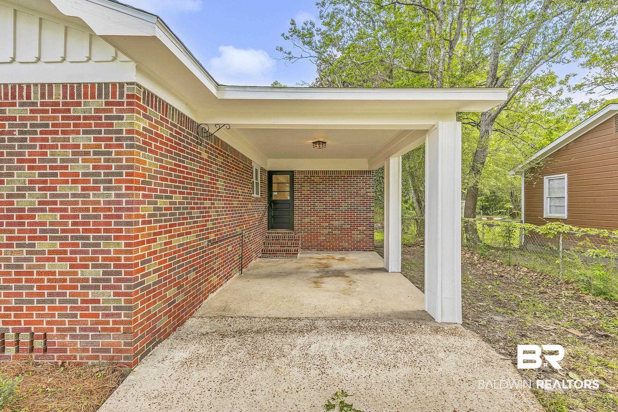 203 Anderson Road Saraland, AL 36571 - Photo 45 of 48 View of patio featuring fence, an attached carport, and concrete driveway
