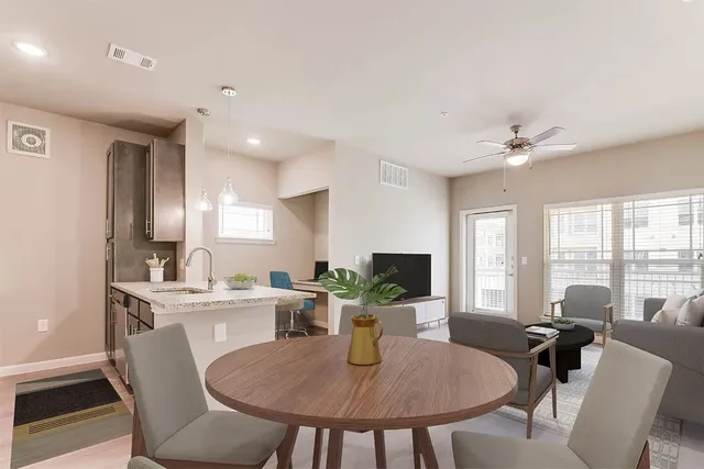 a view of a dining room and livingroom with furniture wooden floor a chandelier