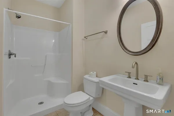 a bathroom with a sink a toilet and a mirror