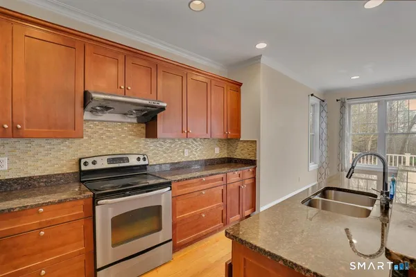 a kitchen with granite countertop a sink stove and cabinets